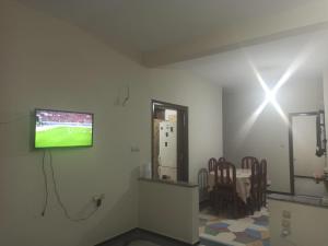 a room with a tv on a wall with chairs at Quartier Anne Marie in Temara