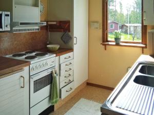 a kitchen with a stove and a sink and a window at Holiday home LULEÅ in Luleå