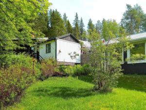 a garden with a white shed and a house at Holiday home LULEÅ in Luleå