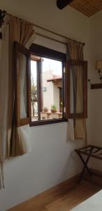 una ventana en una habitación con una pared blanca en Terraza del Molle en San Carlos