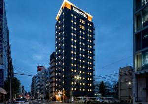 a tall building with lights on in a city at APA Hotel Asakusa Shin Okachimachi Ekimae in Tokyo