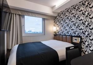 um quarto de hotel com uma cama e uma janela em APA Hotel Asakusa Shin Okachimachi Ekimae em Tóquio