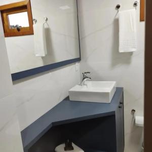 a bathroom with a sink and a mirror and a toilet at Cabanas Sol Poente in Bom Jardim da Serra