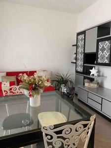 uma sala de estar com uma mesa de vidro e cadeiras em Petit place incantevole a due passi da Milano! em Cologno Monzese