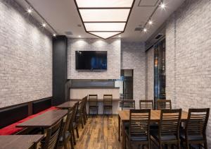 a restaurant with wooden tables and chairs and a tv on the wall at APA Hotel Asakusa Shin Okachimachi Ekimae in Tokyo