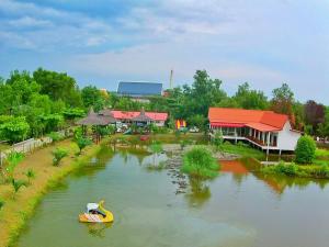 un barco amarillo en un río junto a un edificio en Saeng Tai Amphawa en Samut Songkhram
