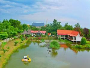 a yellow boat in a river next to a building at Saeng Tai Amphawa in Samut Songkhram