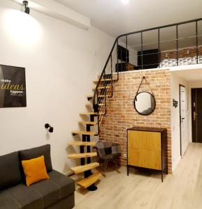 ein Wohnzimmer mit einer Treppe und einer Ziegelwand in der Unterkunft Lividus Czarna Mewa in Świnoujście