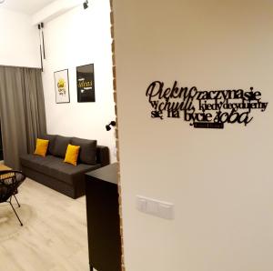 una sala de estar con sofá y un cartel en la pared en Lividus Czarna Mewa, en Świnoujście