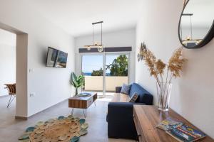 Aronia Luxury Apartments Karpathos في كارباثوس: غرفة معيشة مع أريكة وطاولة