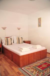 duże łóżko z białą pościelą i poduszkami w pokoju w obiekcie Casa Boby w mieście Murighiol