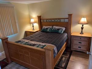 a bedroom with a wooden bed and two night stands at Nunaka Valley Cottage in Anchorage