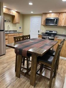 uma cozinha com uma mesa de madeira com cadeiras à volta em Nunaka Valley Cottage em Anchorage