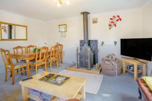 a living room with a table and a fireplace at Ash Cottage in Llantwit Major