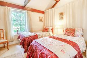 a bedroom with two beds and a window at Ash Cottage in Llantwit Major