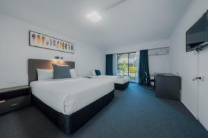 um quarto de hotel com uma cama grande e uma televisão em The Select Inn Gosford em Gosford