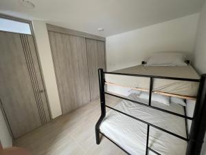 a room with two bunk beds and a closet at Apartamento con piscina y parqueadero a 7 min del centro in Villeta