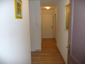 korytarz z białymi ścianami, drewnianymi podłogami i drzwiami w obiekcie Bel appartement plage, 2 chambres, balcon ensoleillé, garage privatif, animaux acceptés, WIFI optionnel - FR-1-674-2 w mieście Berck-sur-Mer