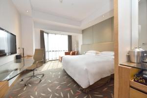 a hotel room with a bed and a flat screen tv at Crowne Plaza Zhongshan Wing On City, an IHG Hotel in Zhongshan