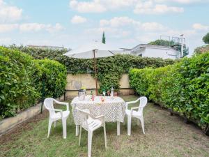 a table and chairs with an umbrella in a yard at Belvilla by OYO Conca degli Dei con giardino in Paestum