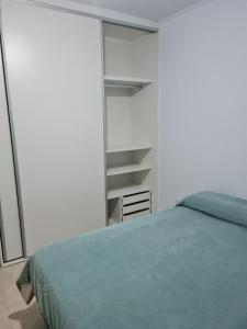 a bedroom with a green bed and a shelf at Del Sur Alquiler temporario in Sunchales