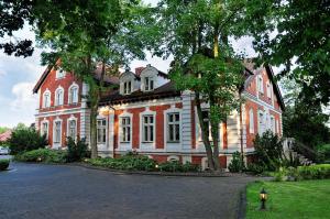 ein großes rotweißes Gebäude auf einer Straße in der Unterkunft Hotel Aleksander in Włocławek