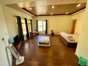 a large room with two beds and a television at Niri-la Guest house Leh in Leh