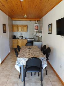 a dining room with a table and chairs and a kitchen at Apartment Lourdes in El Calafate