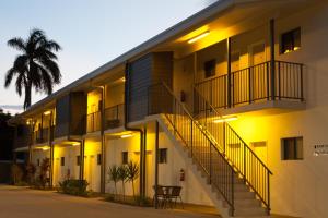 a building with stairs and a palm tree at Abode37 Motel Emerald in Emerald