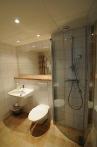 a bathroom with a shower and a toilet and a sink at Hotell Dalsland in Ed