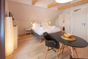 メーアスブルクにあるGästehaus am Schlossplatz, Z. 5のベッド、テーブル、ベッドが備わる客室です。