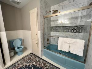 THE CW HOUSE في Claude: حمام مع حوض استحمام أزرق ومرحاض