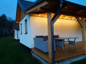 a deck with a table and a couch on a house at Choczewski Zakątek in Choczewo