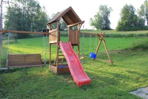 a wooden playground with a slide and a swing at Ośrodek Wczasowy Panorama in Bukowina Tatrzańska
