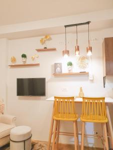 a kitchen with two bar stools and a tv at LFCM Condo Home @ Mesatierra Residences Davao City in Davao City