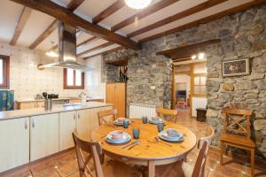 a kitchen and dining room with a wooden table at Erribera - baskeyrentals in Berriatúa