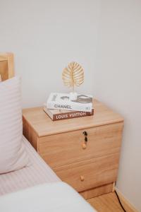 a stack of books sitting on a nightstand next to a bed at LFCM Condo Home @ Mesatierra Residences Davao City in Davao City