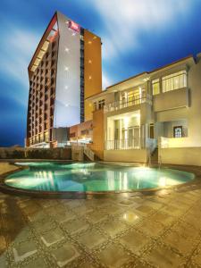 un hotel con piscina frente a un edificio en Ibis Padang, en Padang