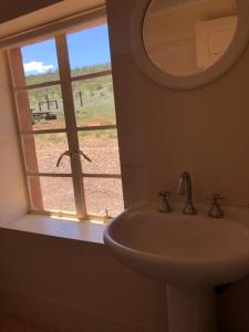 a bathroom with a sink and a window with a view at Nudlamutana Hut - Vulkathunha-Gammon Ranges National Park in Arkaroola