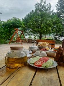 a table with a plate of food and a jar of honey at EleGaya Guest house in Ijevan