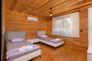 een kamer met 2 bedden in een houten hut bij Villa Olymposgarden in Kumluca