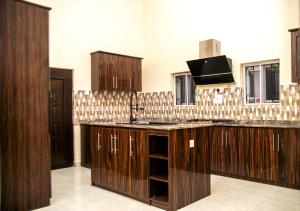a kitchen with wooden cabinets and a sink at Premium 3 Bedroom Villa Upscale Alagbaka Area in Akure