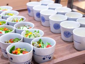 Ein Haufen weißer Becher, gefüllt mit Essen auf einem Tisch. in der Unterkunft Hotel Cuore Nagasaki Ekimae in Nagasaki