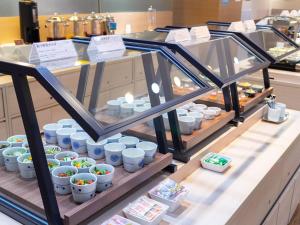 a display case filled with lots of cups and bowls at Hotel Cuore Nagasaki Ekimae in Nagasaki