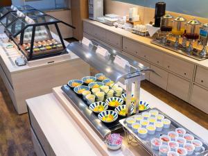 Hotel Cuore Nagasaki Ekimae في ناغاساكي: بوفيه من الكب كيك والكعك في مخبز