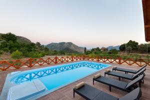 een zwembad met stoelen en een hek eromheen bij Villa Olymposgarden in Kumluca
