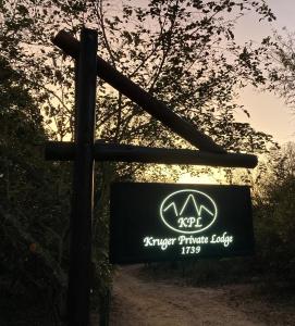 un cartel con una cruz en un camino de tierra en Kruger Private Lodge en Marloth Park