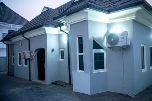 a white building with a fan on the side of it at Modern & Cheerful 2 Bedroom Villa, Alagbaka in Akure