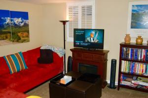 Denver Blue Bear Den 3BR 2BA & Spa في دنفر: غرفة معيشة مع أريكة حمراء وتلفزيون بشاشة مسطحة