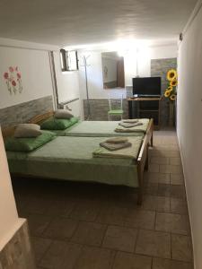 een slaapkamer met een bed, een bureau en een televisie bij Apartmani Luiza in Cres
